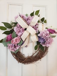 round grapevine wreath with flowers and a bow